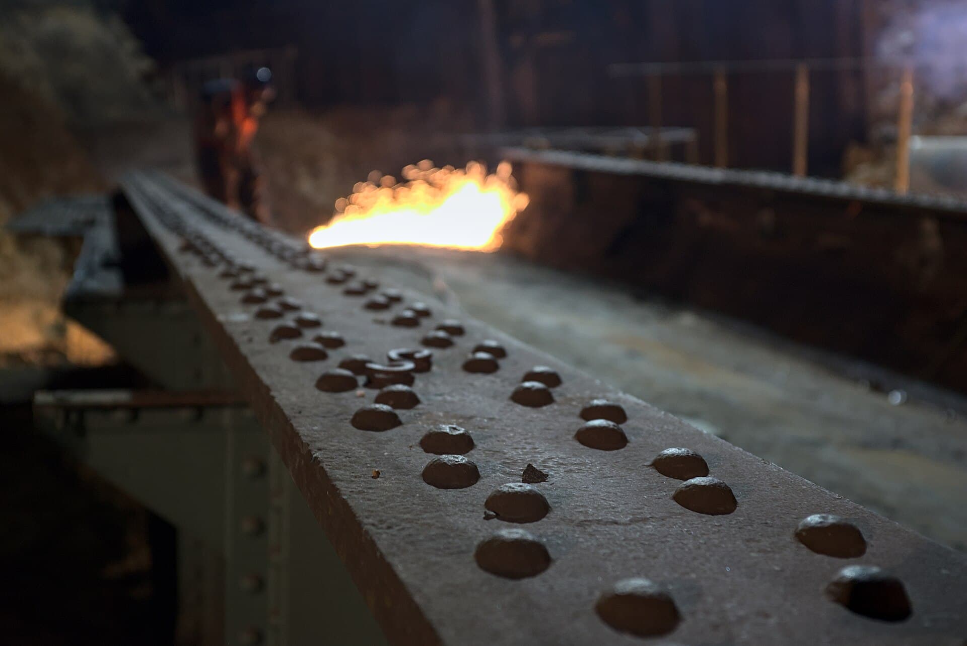 Close-up of riveted structural steel girders — defense-grade manufacturing context